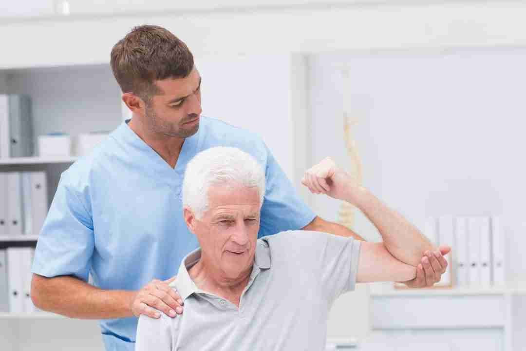 Physical therapist assists patient with maintaining strength