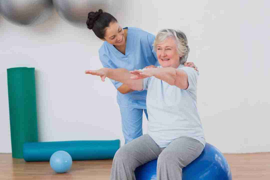 Physical therapist assists patient with balancing