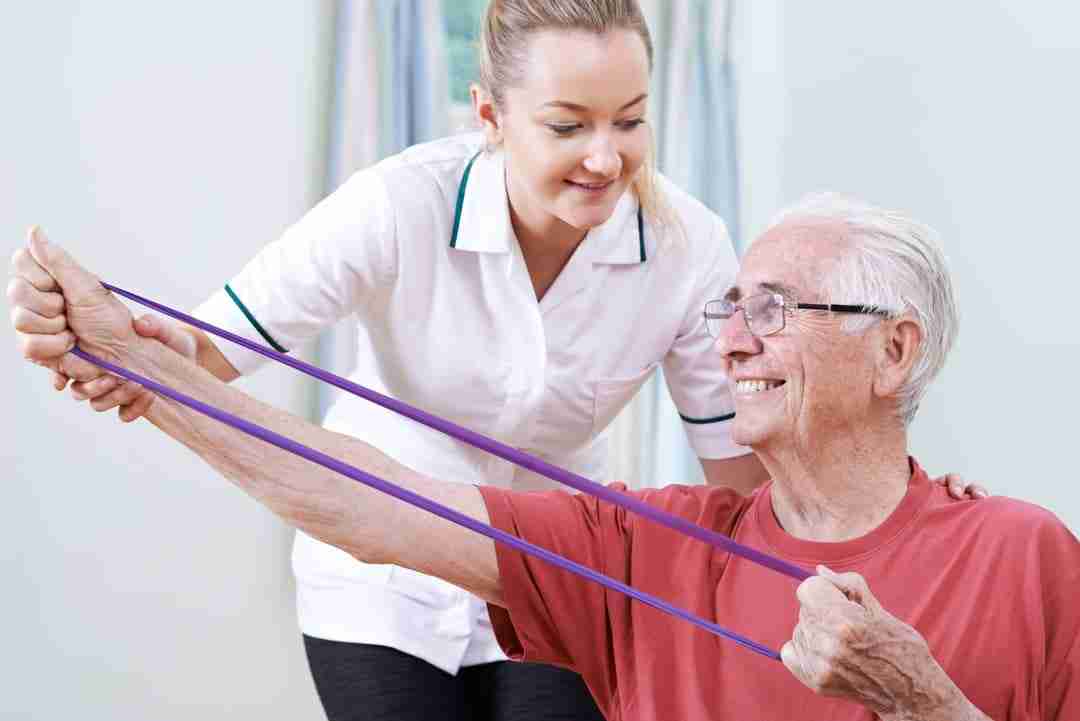 Physical therapist assists older man with tendon health